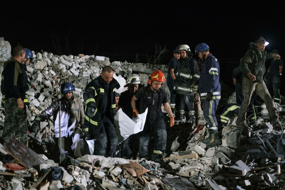 Socorristas ucranianos resgatam um corpo dos escombros de um edifício residencial bombardeado na cidade de Chasiv Yar, região de Donetsk, leste da Ucrânia, em 10/07/2022