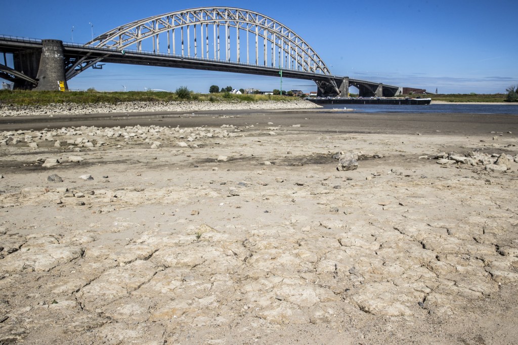 This illustration picture taken on July 24, 2022 shows low water level due to the ongoing drought, affecting shippings and houses in the Waal, near Nijmegen. Earlier this week, Rijkswaterstaat was forced to close the lock in the Maas-Waal Canal due to the very low water level in the Waal.Vincent Jannink / ANP / AFP