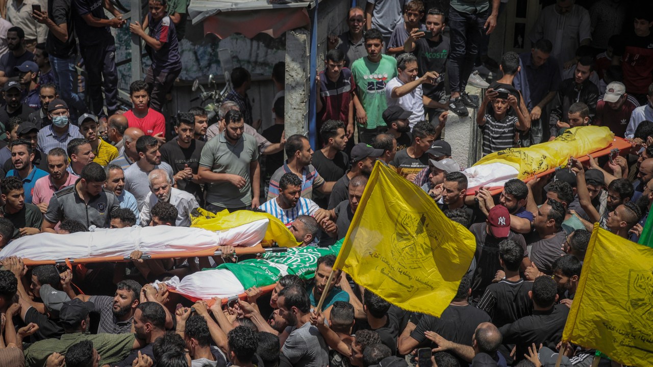 EDITORS NOTE: Graphic content / Palestinians carry the bodies of four teenage Palestinians from the Najm family, during their funeral in Jabalia in the northern Gaza Strip on August 8, 2022, after they were killed during the latest three days of conflict between Israel and Palestinian militants before a ceasefire. (Photo by MOHAMMED ABED / AFP)