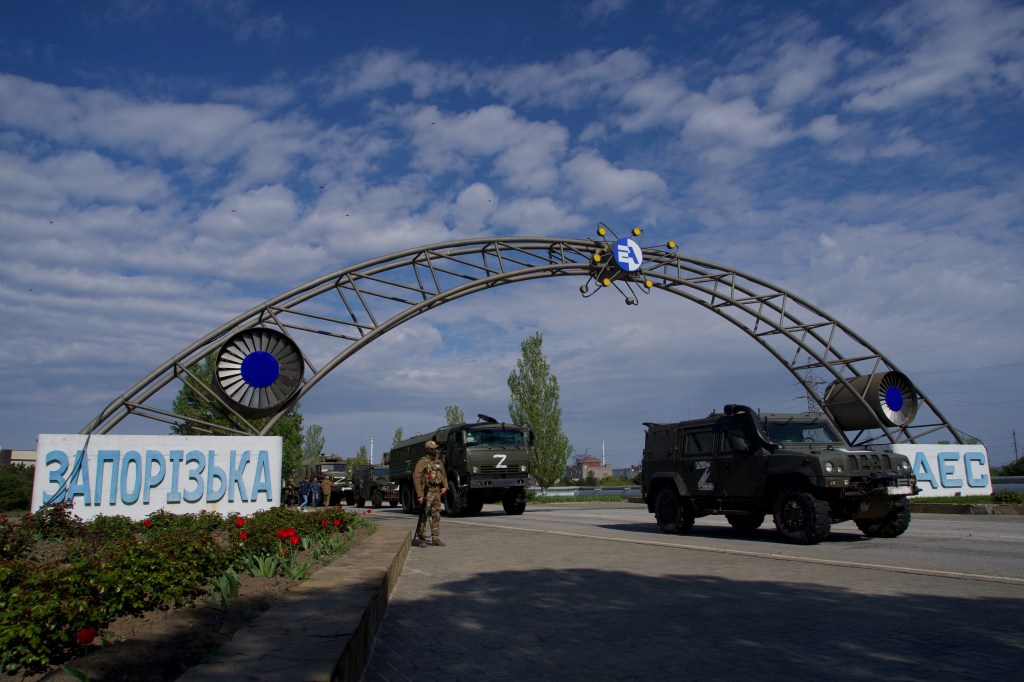 FILES) In this file photo taken on May 1, 2022, Russian military vehicles drive through the gates of the Zaporizhzhia Nuclear Power Station in Energodar. - Kyiv on August 8, 2022, called for the establishment of a demilitarised zone around the nuclear power station in east Ukraine, where recent fighting with Russian forces has raised fears of a nuclear accident. The Kremlin on August 8, 2022, accused Ukrainian forces of firing on the Zaporizhzhia atomic power plant, warning of potential "catastrophic consequences" for Europe. *EDITOR'S NOTE: This picture was taken during a media trip organised by the Russian army.* (Photo by Andrey BORODULIN / AFP)