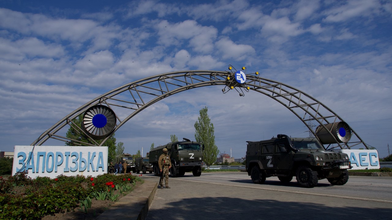 FILES) In this file photo taken on May 1, 2022, Russian military vehicles drive through the gates of the Zaporizhzhia Nuclear Power Station in Energodar. - Kyiv on August 8, 2022, called for the establishment of a demilitarised zone around the nuclear power station in east Ukraine, where recent fighting with Russian forces has raised fears of a nuclear accident. The Kremlin on August 8, 2022, accused Ukrainian forces of firing on the Zaporizhzhia atomic power plant, warning of potential "catastrophic consequences" for Europe. *EDITOR'S NOTE: This picture was taken during a media trip organised by the Russian army.* (Photo by Andrey BORODULIN / AFP)