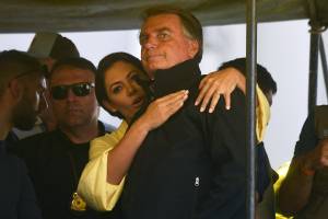 Brazil's President Jair Bolsonaro gestures next to his wife Michelle Bolsonaro during the launching of his re-election campaign for the upcoming national elections in October, in Juiz de Fora, Minas Gerais state, Brazil, on August 16, 2022. - Bolsonaro, 67, launched his campaign with a rally in Juiz de Fora, the small southeastern city where an attacker stabbed and nearly killed him during his 2018 campaign. The attack cemented Bolsonaro in the minds of die-hard supporters as