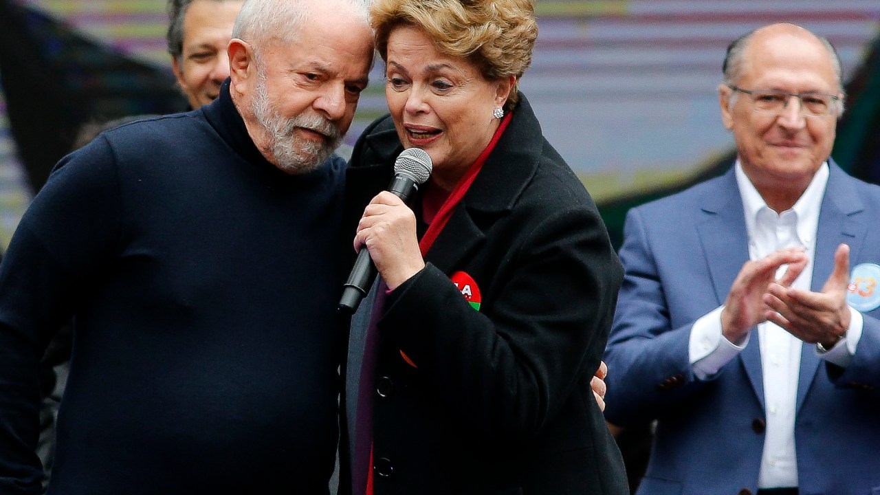 Brazilian presidential candidate for the leftist Workers Party (PT) and former President (2003-2010), Luiz Inacio Lula da Silva (L) greets Brazil's ex-president (2011-2016) Dilma Rousseff during a campaign rally, in Sao Paulo, Brazil, on August 20, 2022. - A recent poll ahead of Brazil's presidential election next October 2, shows former president Luiz Inacio Lula da Silva maintaining a significant lead over current President Jair Bolsonaro, but the right-wing incumbent is gaining ground. (Photo by Miguel SCHINCARIOL / AFP)