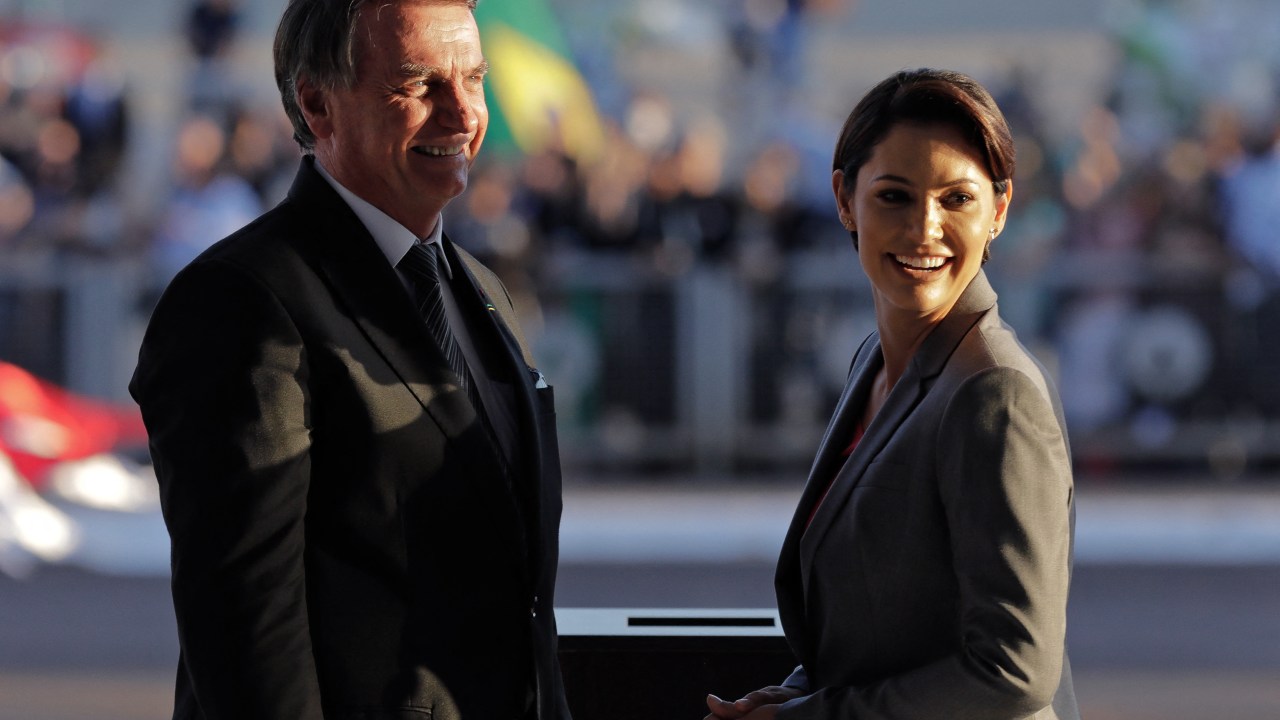 Brazilian President Jair Bolsonaro (L) and First Lady Michelle Bolsonaro wait for the arrival of the urn containing the embalmed heart of Dom Pedro I, founder and first ruler of the Empire of Brazil, during an official ceremony with military honours at Planalto Palace in Brasilia, on August 23, 2022. - Nearly two centuries after it was cut from his corpse and stashed in formaldehyde, the heart of Emperor Pedro I, who declared Brazil's independence from Portugal, returned on August 22 for politically charged commemorations of the South American nation's 200th birthday. (Photo by Sergio LIMA / AFP)