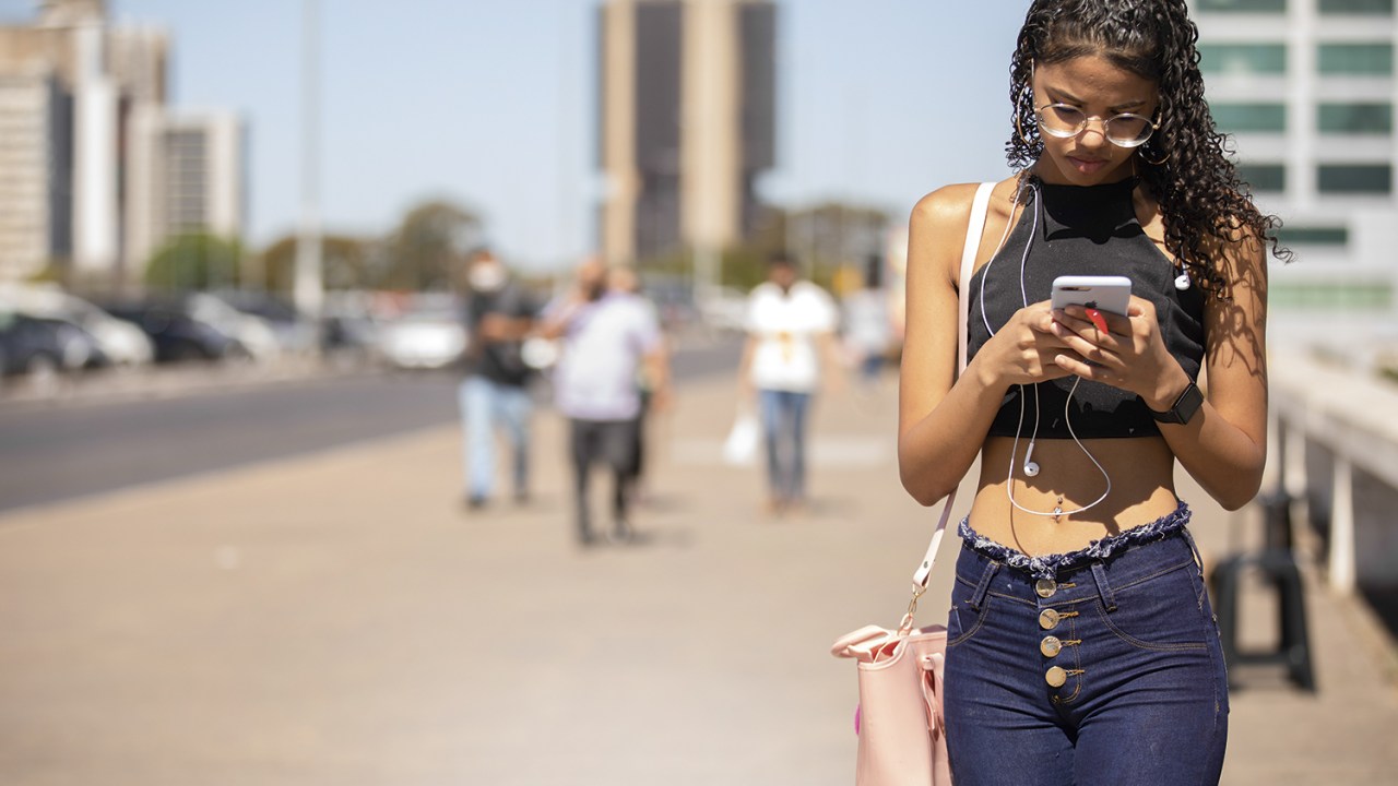 FOCO NA TELA - Jovem com celular no primeiro dia do 5G em Brasília: tráfego de dados mais rápido -