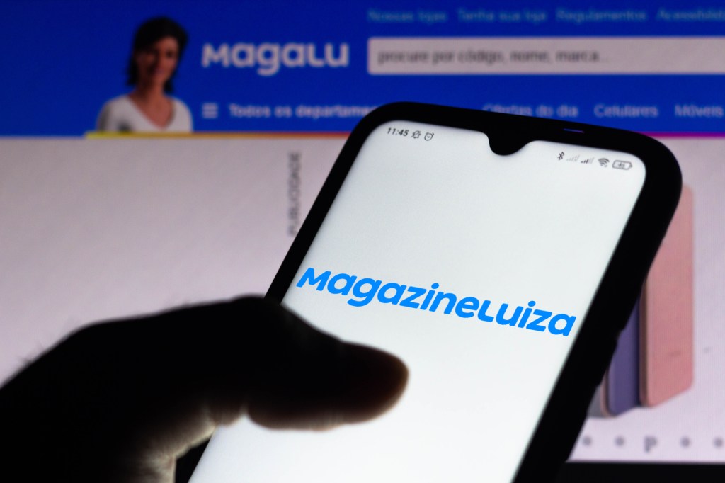 BRAZIL - 2021/04/15: In this photo illustration, the Magazine Luiza logo seen displayed on a smartphone screen with the logo of Magalu in the background. (Photo Illustration by Rafael Henrique/SOPA Images/LightRocket via Getty Images)