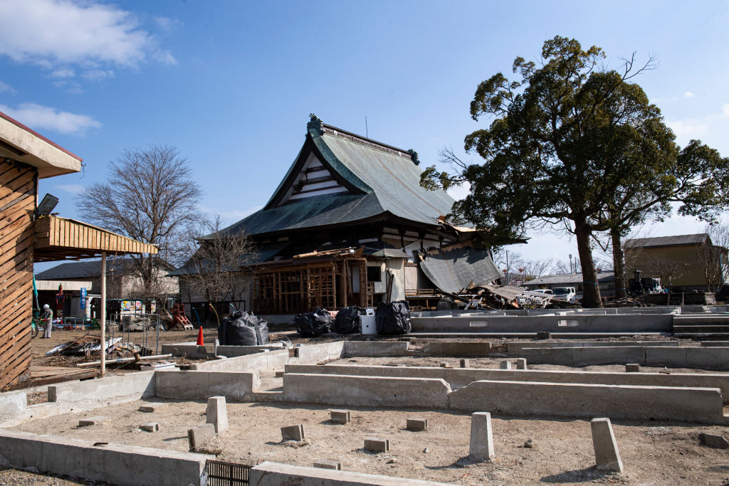 Workers demolish a destroyed temple to rebuild it at Futaba in Fukushima prefecture on Mar 10, 2022. (Photo by Yusuke Harada/NurPhoto via Getty Images)