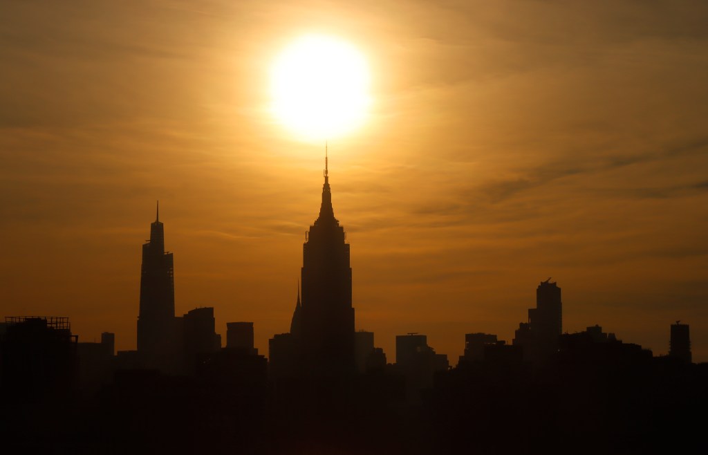 HOBOKEN, NJ - JULY 24: The sun rises behind the Empire State Building and One Vanderbilt as a heatwave continues in New York City on July 24, 2022, as seen from Hoboken, New Jersey. (Photo by Gary Hershorn/Getty Images)