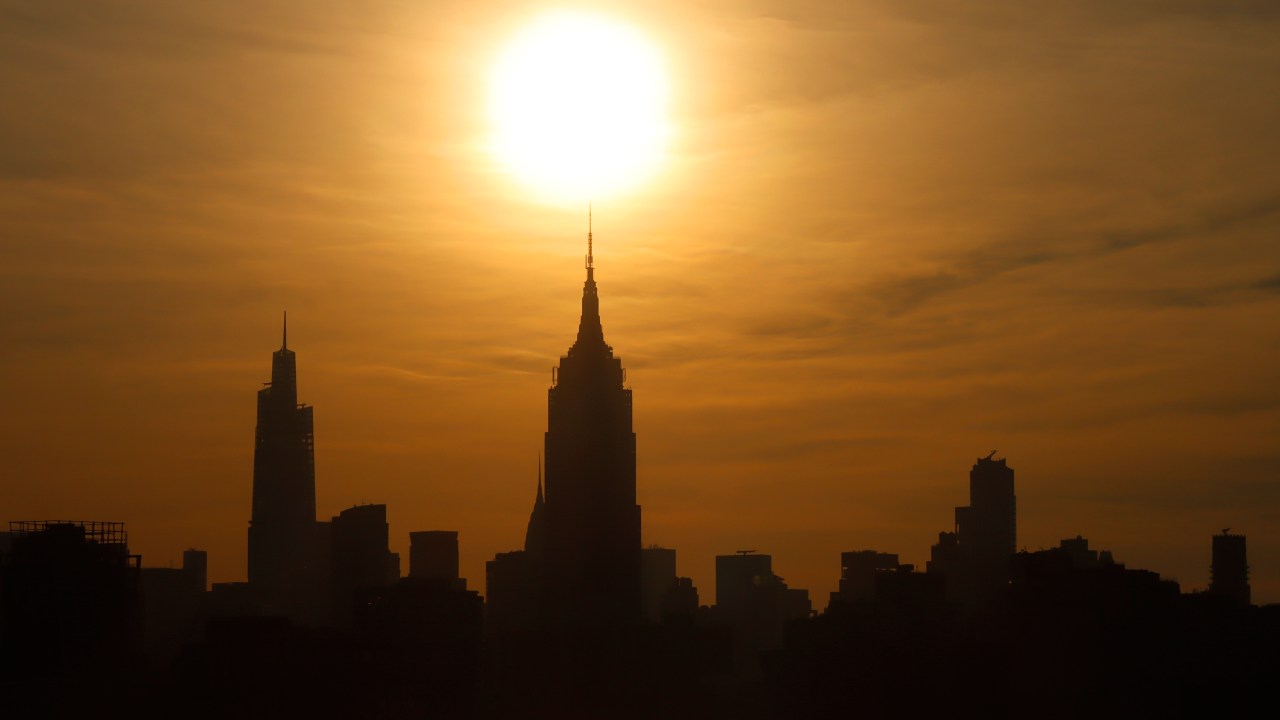HOBOKEN, NJ - JULY 24: The sun rises behind the Empire State Building and One Vanderbilt as a heatwave continues in New York City on July 24, 2022, as seen from Hoboken, New Jersey. (Photo by Gary Hershorn/Getty Images)
