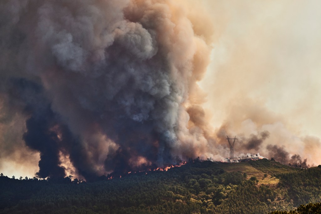 MAFRA, PORTUGAL - JULY 31: A large plume of smoke and flames are seen at a forest fire being fought by 321 firefighters, 84 vehicles and 9 specialized aircraft on July 31, 2022 in Mafra, Portugal. The rise in temperatures this weekend is causing a new wave of forest fires in the country, especially in the central and northern regions. The fires that most concern the authorities this Sunday afternoon are active in the municipalities of Ourém, Mafra and Paços de Ferreira, with some 700 firefighters and 20 aerial means fighting them. (Photo by Horacio Villalobos#Corbis/Corbis via Getty Images)