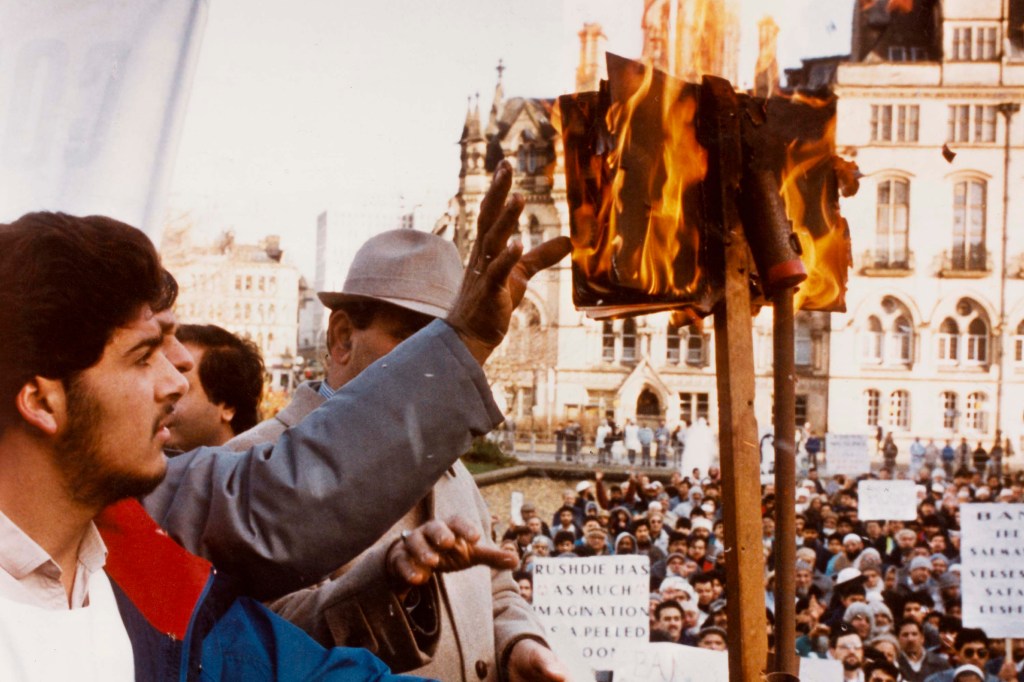 Muslims burning copies of Salman Rushdie's novel 'The Satanic Verses' in front of Bradford City Hall, Bradford, UK, circa 1988. The book was deemed offensive by many Muslims, and Ayatollah Khomeini of Iran issued a fatwa against Rushdie. (Photo by Derek Hudson/Getty Images)
