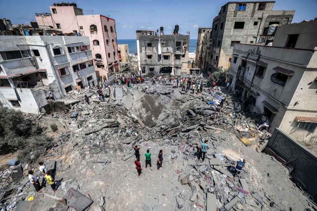 Palestinos inspecionam ruínas de um prédio destruído por um ataque aéreo israelense na Cidade de Gaza, em 06/08/2022.