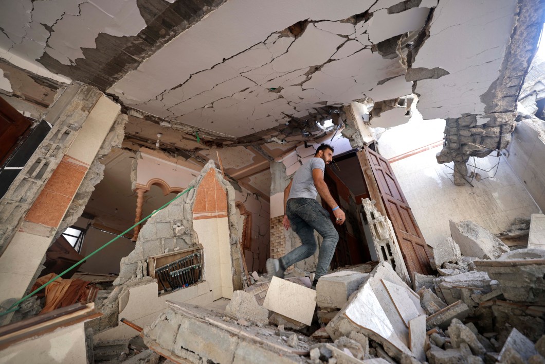 Um palestino caminha em meio aos escombros de sua casa danificada, após ataques aéreos israelenses na cidade de Gaza, em 07 /08/2022.
