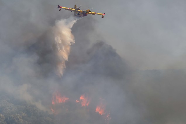 A aeronave de combate `a incêndios francesa Securite Civile Canadair CL-415 lança água sobre florestas em chamas na região de Gignac, sul da França, em 26/07/2022.