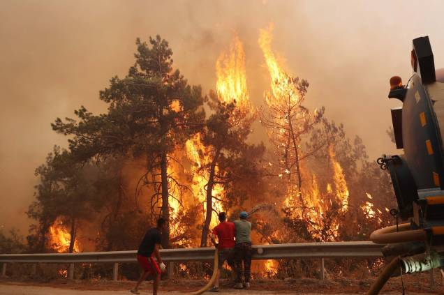 Voluntários ajudam a dominar um incêndio florestal que eclodiu no distrito de Datáa, em Mugla, Turquia, em 13/07/2022. Voluntários ajudam a dominar um incêndio florestal que eclodiu no distrito de Datáa, em Mugla, Turquia, em 13/07/2022.