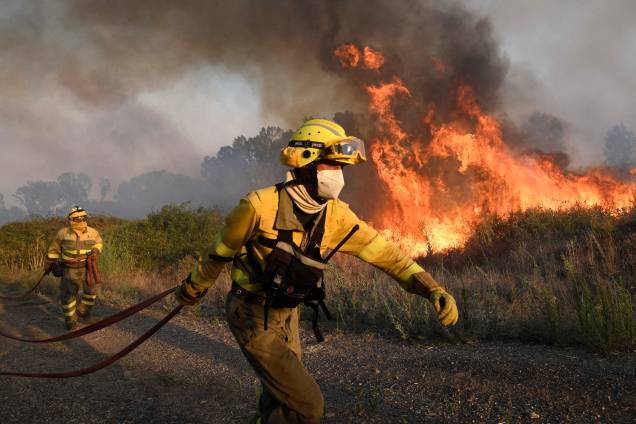 Bombeiros tentam dominar um incêndio florestal próximo à vila de Tabara, região de Zamora, norte da Espanha, em 18/07/2022.