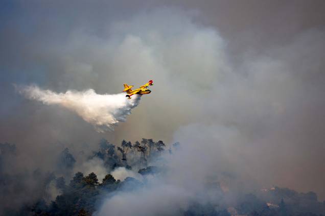 Avião sobrevoa região de incêndio florestal próximo à cidade de Massarosa, região da Toscana, centro da Itália, em 20/06/2022.