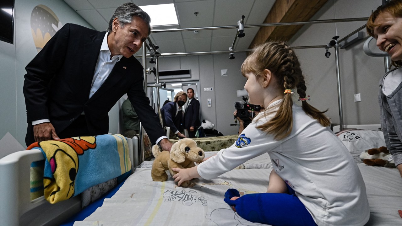 US' Secretary of State Antony Blinken gives a gift to Marina, 6, from Kherson region, during his visit at a children's hospital in Kyiv on September 8, 2022. - Secretary of State Antony Blinken on August 8, 2022, made a surprise trip to Kyiv as the United States unveiled nearly $2.7 billion in new military support to Ukraine and neighbours to face Russia. (Photo by Genya SAVILOV / POOL / AFP)