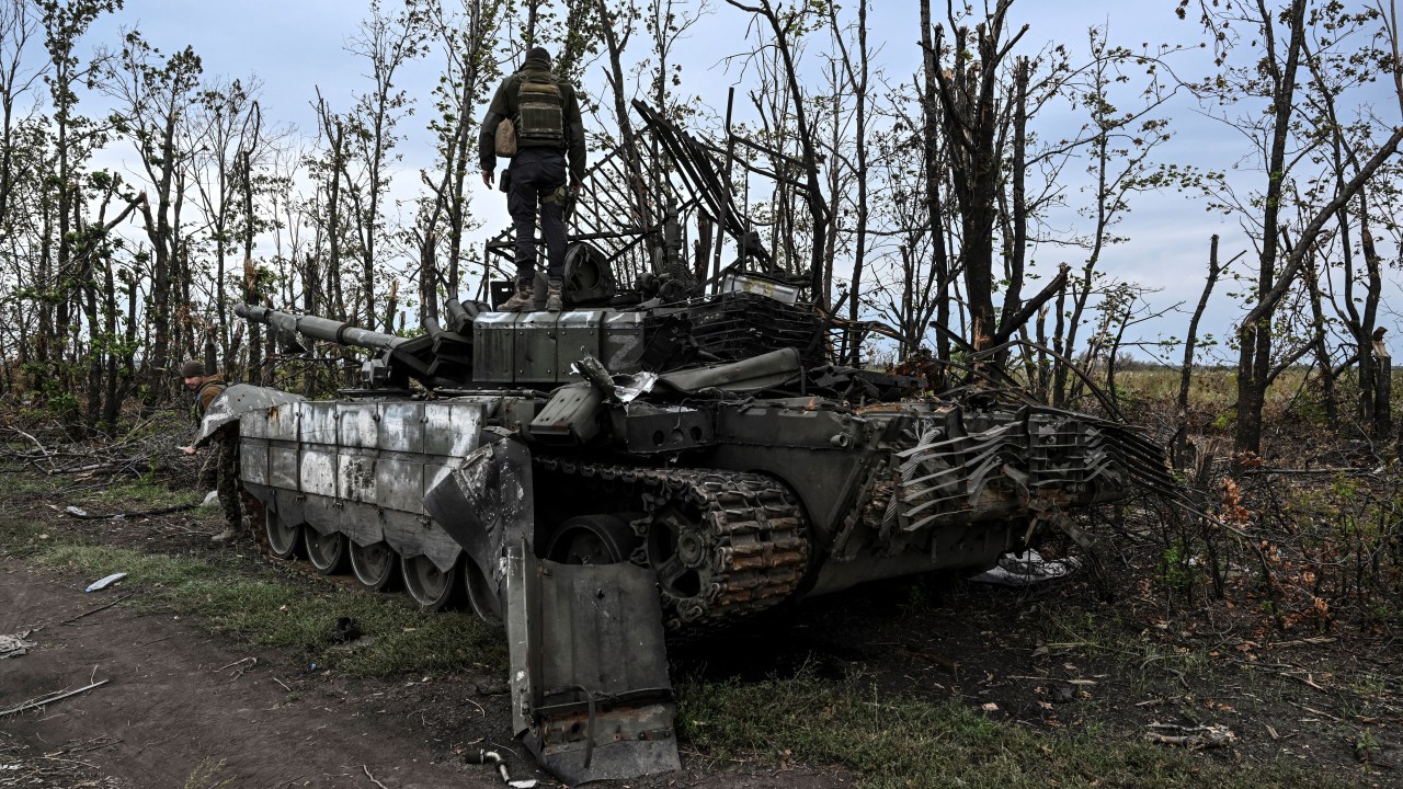 This photograph taken on September 11, 2022, shows a Ukranian soldier standing atop an abandoned Russian tank near a village on the outskirts of Izyum, Kharkiv Region, eastern Ukraine, amid the Russian invasion of Ukraine. - Ukraine forces said that their lightning counter-offensive took back more ground in the past 24 hours, as Russia replied with strikes on some of the recaptured ground. The territorial shifts were one of Russia's biggest reversals since its forces were turned back from Kyiv in the earliest days of the nearly seven months of fighting, yet Moscow signalled it was no closer to agreeing a negotiated peace. (Photo by Juan BARRETO / AFP)
