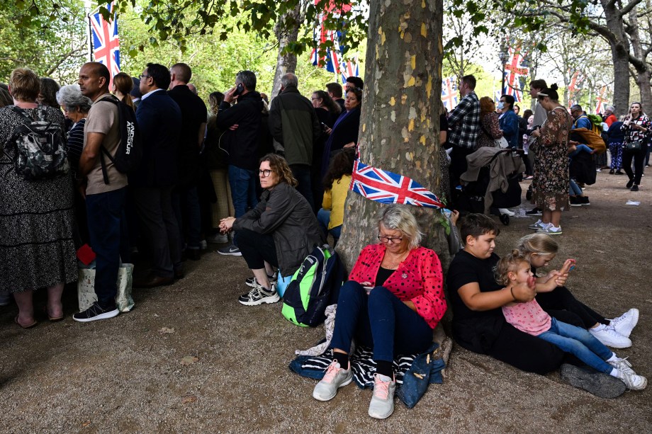 O público espera no The Mall, no centro de Londres, a procissão cerimonial do caixão da rainha Elizabeth II, do Palácio de Buckingham ao Westminster Hall em 14 de setembro de 2022.