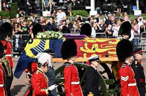 BRITAIN-ROYALS-QUEEN-DEATH O caixão da Rainha Elizabeth II, adornado com um Estandarte Real e a Coroa Imperial do Estado e puxado por uma Carruagem da Tropa Real de Artilharia do Rei, é retratado durante uma procissão do Palácio de Buckingham ao Palácio de Westminster, em Londres, em 14 de setembro. , 2022. - A rainha Elizabeth II ficará em estado no Westminster Hall, dentro do Palácio de Westminster, de quarta-feira até algumas horas antes de seu funeral na segunda-feira, com enormes filas esperadas para passar por seu caixão para prestar homenagem. (Foto de Marco BERTORELLO/AFP)