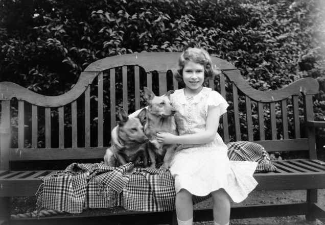 Elizabeth ainda criança posando com dois cachorros, em 1936 -