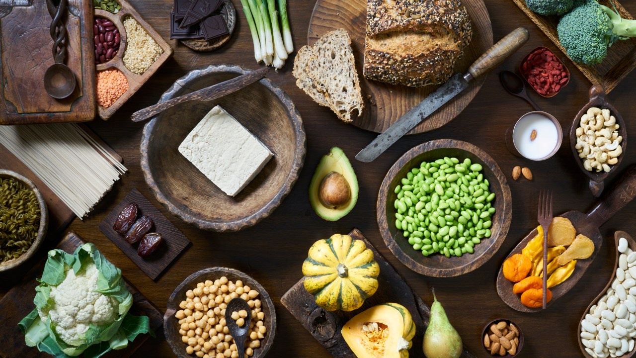 Foto aérea de comida vegana saudável, incluindo frutas, legumes, tofu e feijão