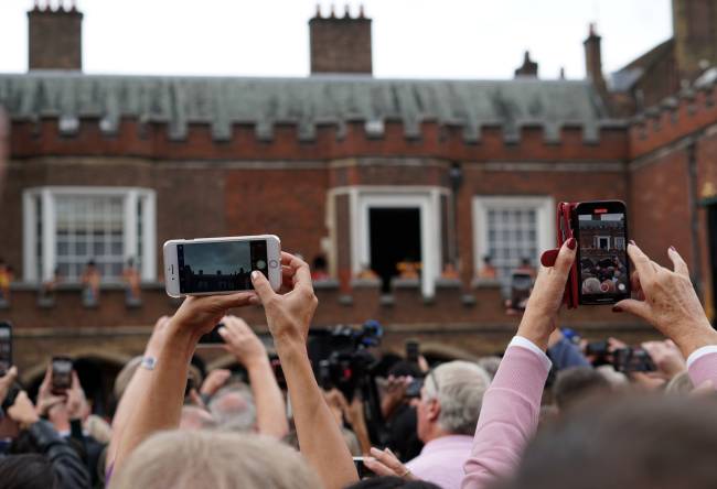 Curiosos em busca da melhor foto da proclamação do rei Charles III na entrada do Palácio Saint James, em Londres /