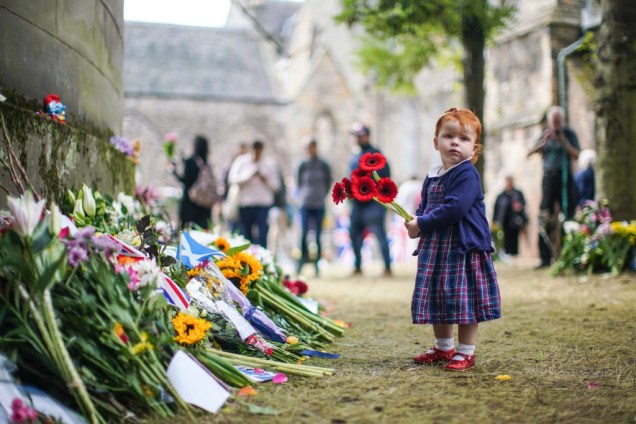 Uma jovem é vista colocando flores em memória da falecida rainha Elizabeth II fora do Palácio de Holyroodhouse - 12/09/2022
