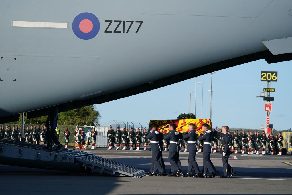 EDINBURGH, SCOTLAND - SEPTEMBER 13: Pallbearers from the Queen's Colour Squadron of the Royal Air Force (RAF) carry the coffin of Queen Elizabeth II, draped in the Royal Standard of Scotland, into a RAF C17 aircraft at Edinburgh airport on September 13, 2022 in Edinburgh, Scotland. The coffin carrying Her Majesty Queen Elizabeth II leaves St Giles Church travelling to Edinburgh Airport where it will be flown to London and transferred to Buckingham Palace by road. Queen Elizabeth II died at Balmoral Castle in Scotland on September 8, 2022, and is succeeded by her eldest son, King Charles III. (Photo by Andrew Milligan - WPA Pool/Getty Images)