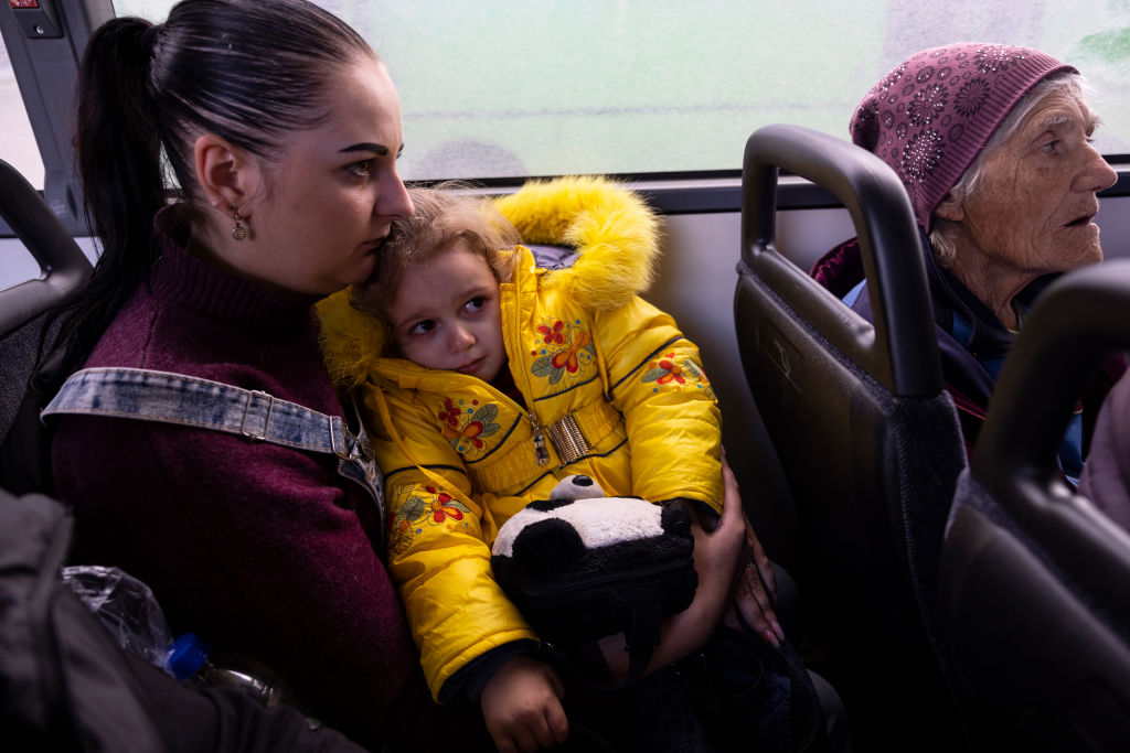SHEVCHENKOVE, UKRAINE - SEPTEMBER 22: Julia holds her daughter Elizabeth, 3, after fleeing the front lines of Kupiansk on board a refugee bus headed to Kharkiv on September 22, 2022 in the Kharkiv region, Ukraine. In recent weeks, Ukrainian forces have reclaimed villages east and south of Kharkiv, as Russian forces have withdrawn from areas they've occupied since early in the war. (Photo by Paula Bronstein/Getty Images)
