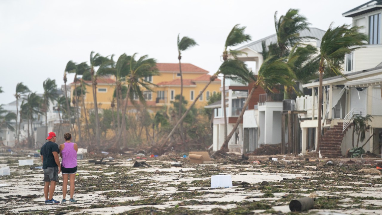 BONITA SPRINGS, FL - 29 DE SETEMBRO: As pessoas caminham pela praia olhando para a propriedade danificada pelo furacão Ian em 29 de setembro de 2022 em Bonita Springs, Flórida. A tempestade atingiu os EUA em Cayo Costa, Flórida, e trouxe ventos fortes, tempestades e chuva para a área, causando graves danos.
