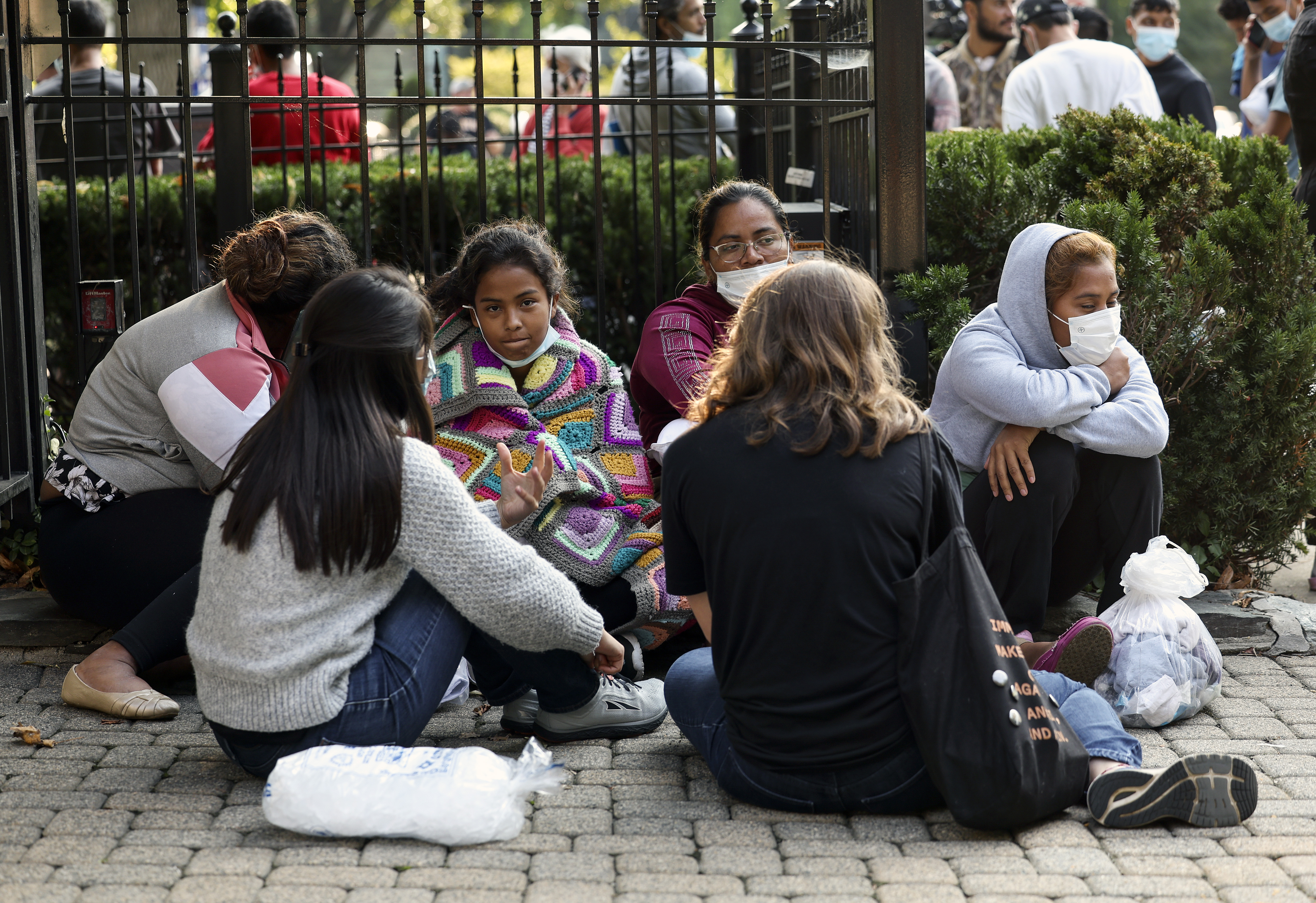 WASHINGTON, DC - SEPTEMBER 15: Migrants from Central and South America wait near the residence of US Vice President Kamala Harris after being dropped off on September 15, 2022 in Washington, DC. Texas Governor Greg Abbott dispatched buses carrying migrants from the southern border to Harris' home early Thursday morning. (Photo by Kevin Dietsch/Getty Images)