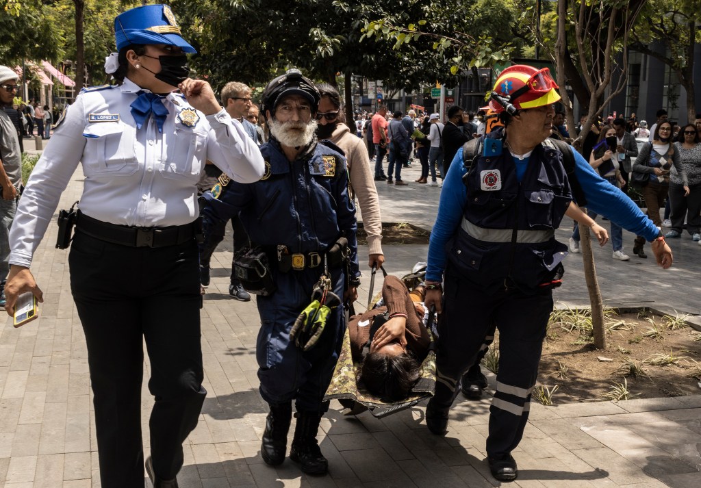 MEXICO CITY, MEXICO - SEPTEMBER 19: Rescuers carry a person on a stretcher after a 7.7 magnitude quake that struck the west coast in Michoacan State, was felt in Mexico City right after a drill to commemorate two prior earthquakes that took place on this same date in 1985 and 2017 on September 19, 2022 in Mexico City, Mexico. So far authorities confirmed one dead. (Photo by Cristopher Rogel Blanquet/Getty Images)
