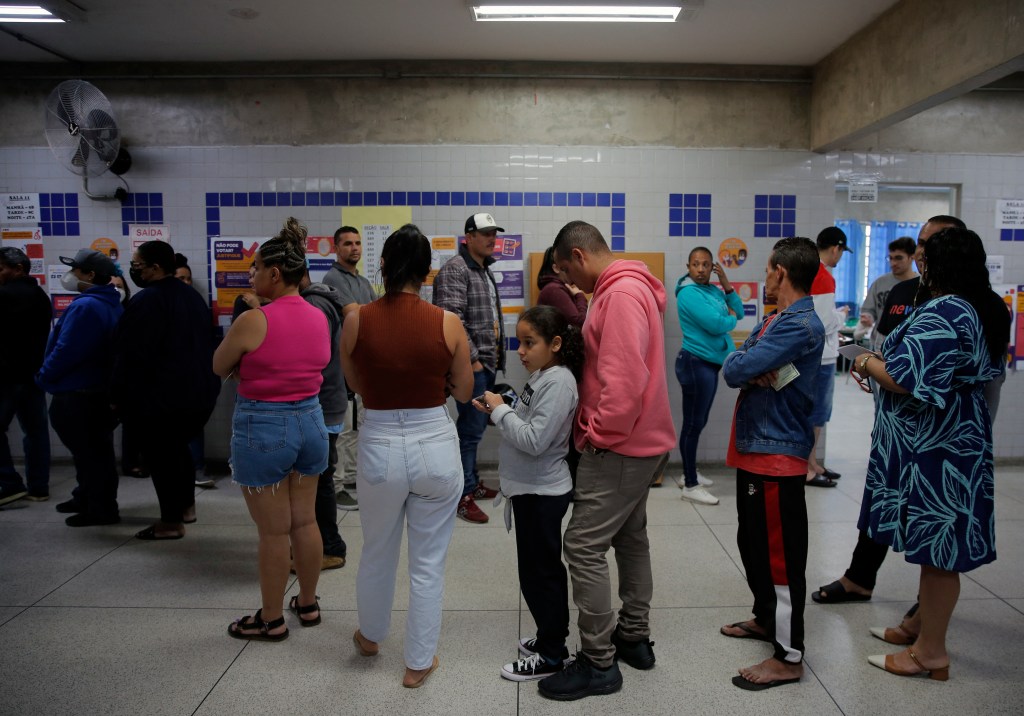 People queue to vote during the legislative and presidential election, in Sao Paulo, Brazil, on October 2, 2022. - Voting began early Sunday in South America's biggest economy, plagued by gaping inequalities and violence, where voters ar expected to choose between far-right incumbent Jair Bolsonaro and leftist front-runner Luiz Inacio Lula da Silva, any of which must garner 50 percent of valid votes, plus one, to win in the first round. (Photo by CAIO GUATELLI / AFP)