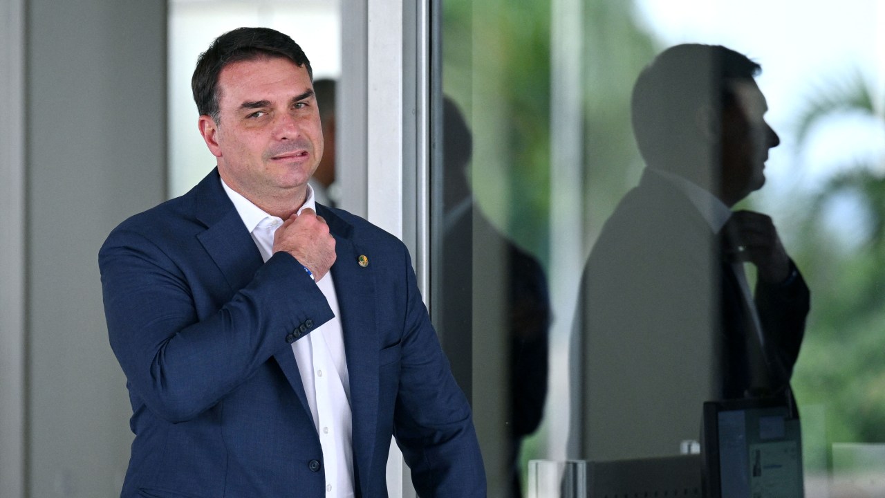 Brazilian Senator Flavio Bolasonaro, son of President Jair Bolsonaro, gestures as he leaves Planalto Palace in Brasilia, on October 4, 2022. - Brazil's bitterly divisive presidential election will be decided in a runoff on October 30 as incumbent Jair Bolsonaro beat first-round expectations to finish a closer-than-expected second to front-runner Luiz Inacio Lula da Silva in the October 2 first round. (Photo by EVARISTO SA / AFP)