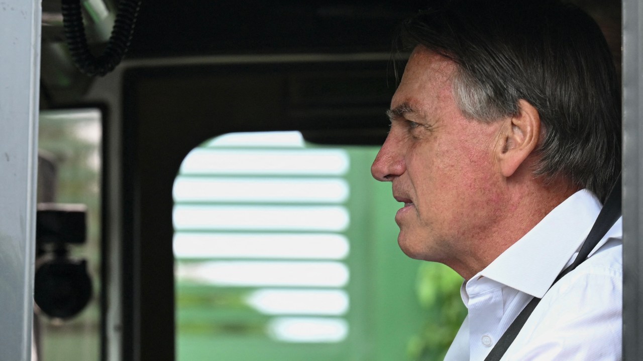 Brazilian President and re-election candidate Jair Bolsonaro gestures as he drives a truck to film an electoral TV advertisement in Brasilia, on October 8, 2022. - Brazil's bitterly divisive presidential election will be decided in a runoff on October 30 as incumbent Jair Bolsonaro beat first-round expectations to finish a closer-than-expected second to front-runner Luiz Inacio Lula da Silva in the October 2 first round. (Photo by EVARISTO SA / AFP).