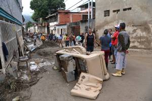 Moradores caminham entre os escombros de casas destruídas levadas por um deslizamento de terra durante fortes chuvas em Las Tejerias, estado de Aragua, Venezuela. 10/10/2022