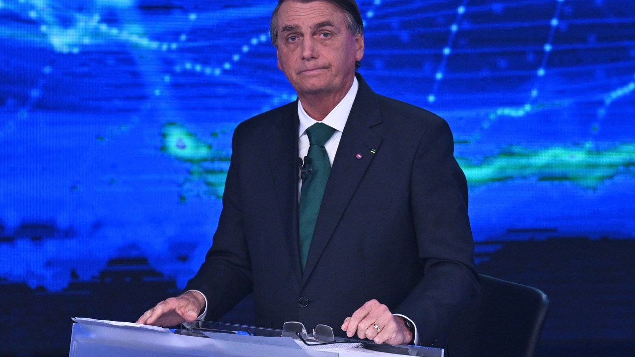 Brazilian President and presidential candidate Jair Bolsonaro gestures before a televised presidential debate in Sao Paulo, Brazil, on October 16, 2022. - President Jair Bolsonaro and former President Luiz Inácio Lula da Silva face each other this Sunday night in the first face-to-face debate, in which they will try to take advantage 14 days before the second round of the presidential elections in Brazil. (Photo by NELSON ALMEIDA / AFP)