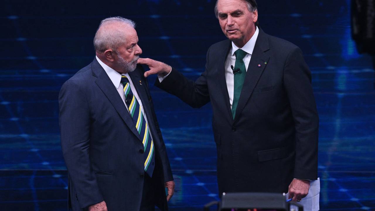 Brazilian former president (2003-2010) and presidential candidate for the leftist Workers Party (PT), Luiz Inacio Lula da Silva (L), and Brazilian President and presidential candidate Jair Bolsonaro (R) gesture during a televised presidential debate in Sao Paulo, Brazil, on October 16, 2022. - President Jair Bolsonaro and former President Luiz Inácio Lula da Silva face each other this Sunday night in the first face-to-face debate, in which they will try to take advantage 14 days before the second round of the presidential elections in Brazil. (Photo by NELSON ALMEIDA / AFP)