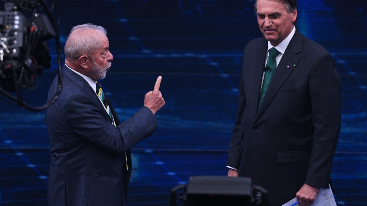 Brazilian former president (2003-2010) and presidential candidate for the leftist Workers Party (PT), Luiz Inacio Lula da Silva (L), and Brazilian President and presidential candidate Jair Bolsonaro (R) gesture during a televised presidential debate in Sao Paulo, Brazil, on October 16, 2022. - President Jair Bolsonaro and former President Luiz Inácio Lula da Silva face each other this Sunday night in the first face-to-face debate, in which they will try to take advantage 14 days before the second round of the presidential elections in Brazil. (Photo by NELSON ALMEIDA / AFP)
