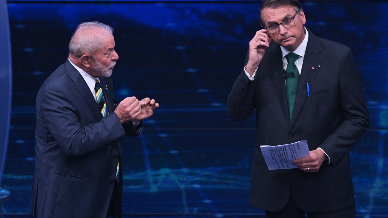 Brazilian former president (2003-2010) and presidential candidate for the leftist Workers Party (PT), Luiz Inacio Lula da Silva (L), speaks next to Brazilian President and presidential candidate Jair Bolsonaro (R) during a televised presidential debate in Sao Paulo, Brazil, on October 16, 2022. - President Jair Bolsonaro and former President Luiz Inácio Lula da Silva face each other this Sunday night in the first face-to-face debate, in which they will try to take advantage 14 days before the second round of the presidential elections in Brazil. (Photo by NELSON ALMEIDA / AFP)
