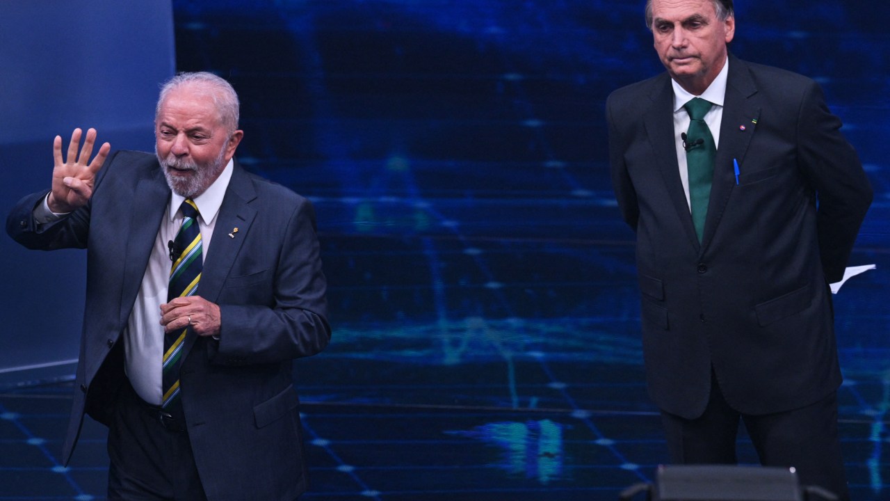 Brazilian former president (2003-2010) and presidential candidate for the leftist Workers Party (PT), Luiz Inacio Lula da Silva (L), speaks next to Brazilian President and presidential candidate Jair Bolsonaro (R) during a televised presidential debate in Sao Paulo, Brazil, on October 16, 2022. - President Jair Bolsonaro and former President Luiz Inácio Lula da Silva face each other this Sunday night in the first face-to-face debate, in which they will try to take advantage 14 days before the second round of the presidential elections in Brazil. (Photo by NELSON ALMEIDA / AFP)