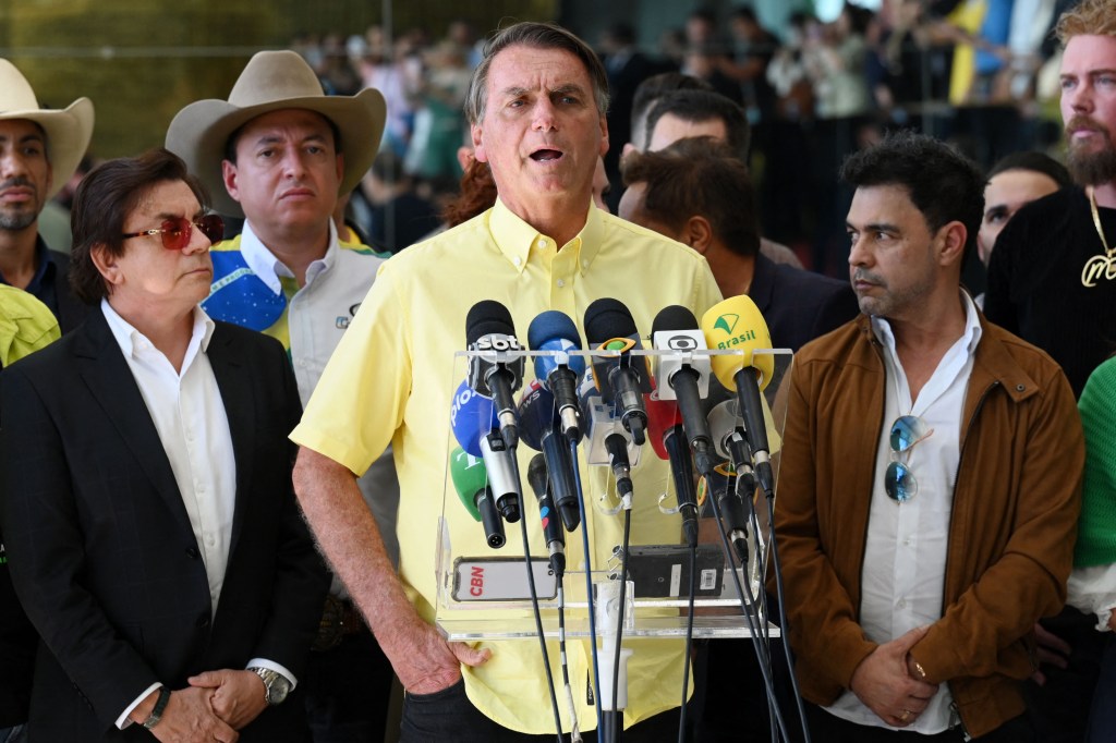 Brazilian President and presidential candidate Jair Bolsonaro speaks to the media during a meeting with country singers at the Alvorada Palace in Brasilia, Brazil, on October 17, 2022. - Lula da Silva and president Jair Bolsonaro will face in the second round of a presidential election on October 30, with the expectation of a close contest pushing both sides to intensify their attacks in the run-up. (Photo by EVARISTO SA / AFP)
