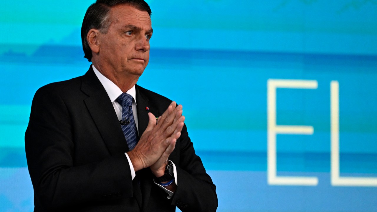 Brazilian President and reelection candidate for the Liberal Party (PL) Jair Bolsonaro gestures before the start of the television debate at the Globo TV studio in Rio de Janeiro, Brazil, on October 28, 2022. - After a bitterly divisive campaign and inconclusive first-round vote, Brazil will elect its next president on October 30, in a cliffhanger runoff between far-right incumbent Jair Bolsonaro and veteran leftist Luiz Inacio Lula da Silva. (Photo by MAURO PIMENTEL / AFP)