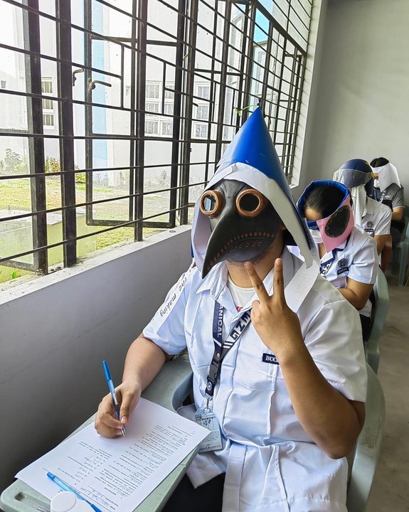 Estudante usa mascára de bico de pássaro parecida com a que médicos usavam durante e pandemia da peste bubônica em Legazpi, nas Filipinas.