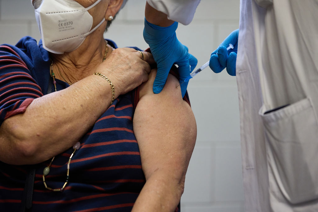 Uma mulher idosa recebe a quarta dose de uma vacina contra a Covid-19, em Mardi, na Espanha