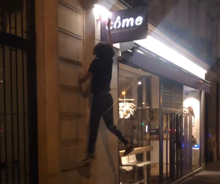 Atletas de parkour do grupo On The Spot desligam letreiros de lojas em Paris.