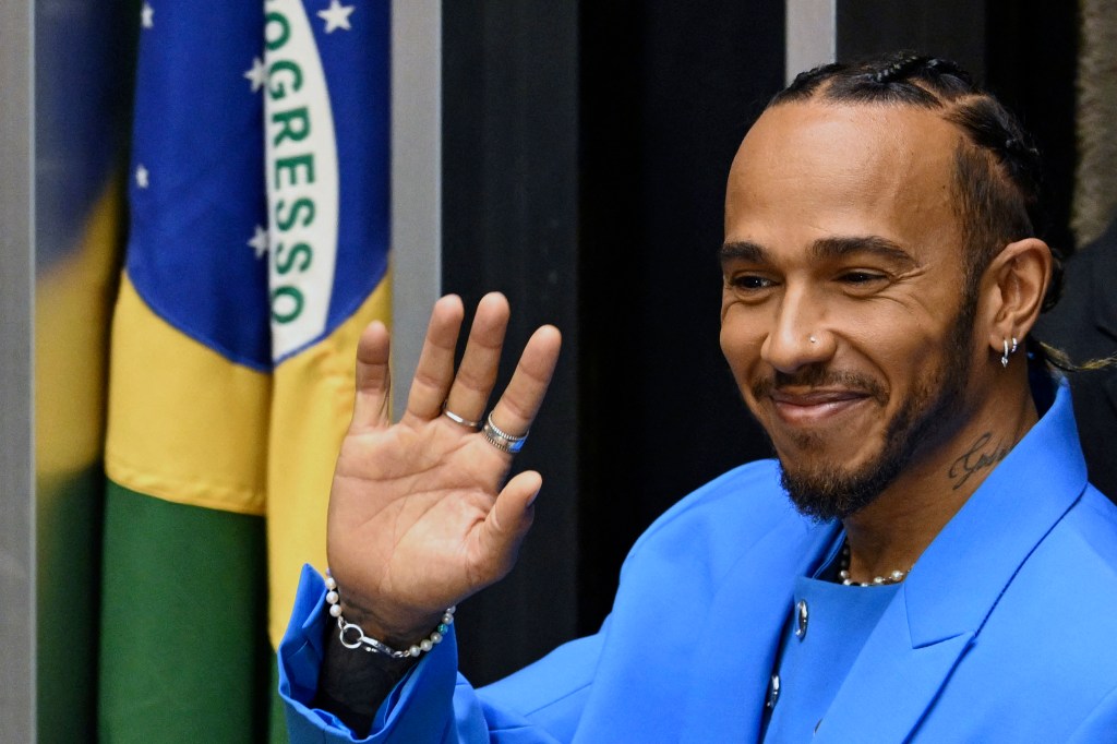 British F1 driver Lewis Hamilton waves at the audience after being awarded the Honorary Brazilian Citizenship, during a ceremony at the National Congress, in Brasilia on 7 November 2022. (Photo by EVARISTO SA / AFP)
