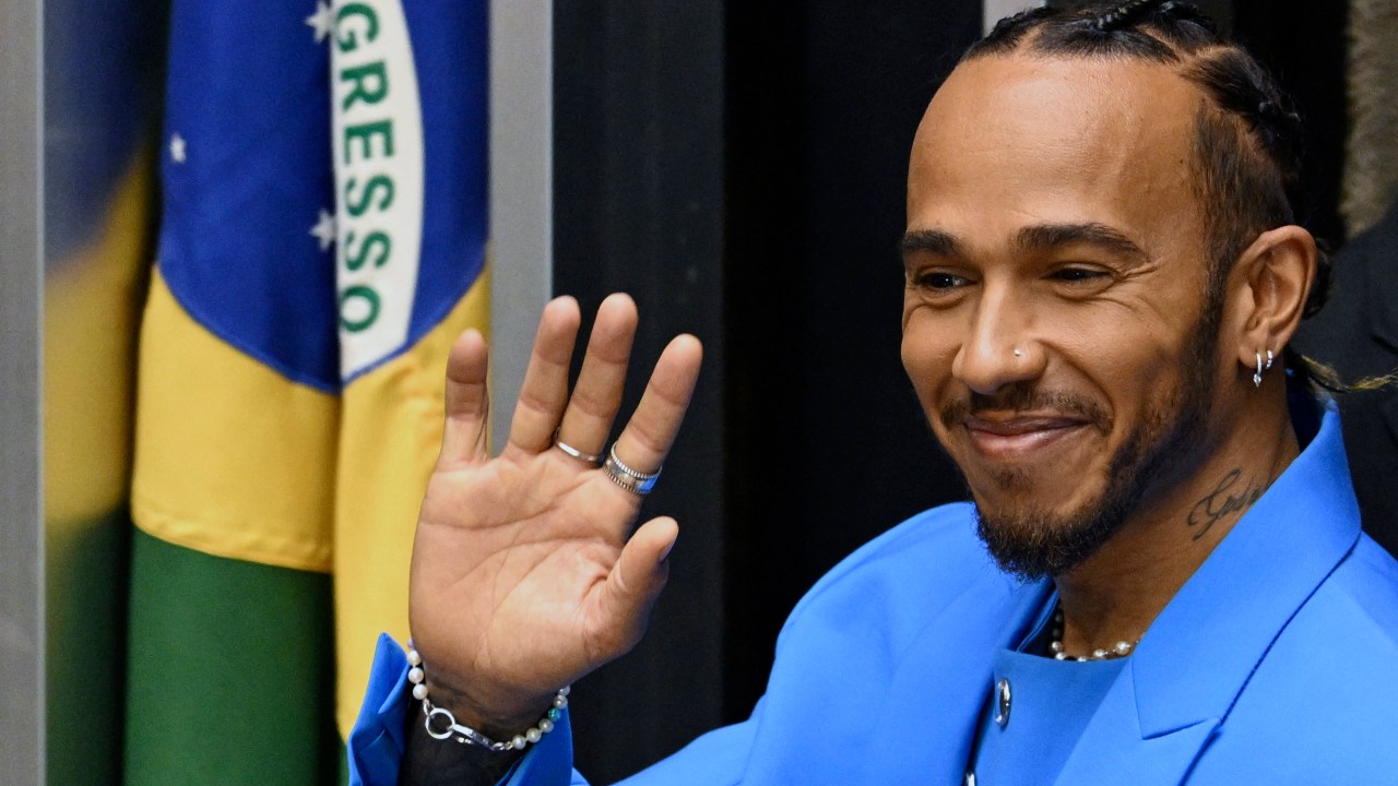 British F1 driver Lewis Hamilton waves at the audience after being awarded the Honorary Brazilian Citizenship, during a ceremony at the National Congress, in Brasilia on 7 November 2022. (Photo by EVARISTO SA / AFP)